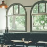Los sillones son una solución elegante y que ahorra espacio, ideal para restaurantes, cafeterías y bares. La creación de áreas íntimas y acogedoras para que los clientes coman y beban proporciona un elemento de privacidad y permite un gran diseño en el interior de cualquier local. Ahorra espacio con los sillones para restaurantes Darse cuenta de todo el potencial del espacio en un local es importante para el diseño interior de un restaurante. Optimizar el espacio es clave para maximizar las ganancias en muchos lugares, por eso los sillones pueden ser una opción interesante para ahorrar espacio y aprovechar toda la zona, especialmente cuando las áreas son limitadas. Los sillones crean cabinas acogedoras e íntimas para que los comensales coman y beban, y proporciona un cierto grado de privacidad. Estos asientos, cuidadosamente diseñados y tapizados, crean un punto focal dentro del interior de cualquier bar o restaurante y pueden formar un diseño central alrededor del cual se pueden colocar estratégicamente otros muebles. Estética y diseño de sillones para restaurantes Una consideración clave en los diseños de interior para restaurantes es el uso de muebles con varios niveles diferentes para evitar la estética utilitaria de un interior de estilo comedor donde todos los muebles tienen la misma altura. Los sillones tipo banqueta te permiten un diseño con diferentes tipos de alturas. Crear un ambiente íntimo para que los clientes obtengan un elemento de privacidad es un factor importante para determinados estilos de restaurantes. Los asientos de banqueta con respaldo alto pueden proporcionar este nivel de intimidad de manera efectiva, especialmente en bares y restaurantes para que tus comensales puedan tener una cena o reunión privada. Cabinas con sillones para crear un tráfico fluido Los sillones también se pueden usar para indicar la dirección principal del tráfico a través del restaurante o bar, para permitir que el personal se mueva de manera eficiente y con una interrupción mínima del servicio. Se pueden usar para dividir las diferentes zonas de un espacio, por ejemplo, separando claramente el área de bar del área de restaurante. Materiales y tapicería La elección correcta de telas en cualquier ambiente de restaurante requiere una cuidadosa reflexión. Elegir la tapicería correcta para los asientos es particularmente importante ya que los largos tramos de tela lisa a veces pueden verse aburridos y poco atractivos. Puede ser efectivo introducir telas de dos tonos, espaldas abotonadas o acanaladas para agregar textura e interés. Se derrama más comida y bebida en este tipo de asientos en comparación con las sillas sueltas, por lo que optar por la tapicería de cuero sintético que se puede limpiar fácilmente alargará la vida útil de tus sillones para restaurante. Alternativamente, si se prefiere una tapicería textil, es aconsejable considerar diseños estampados.
